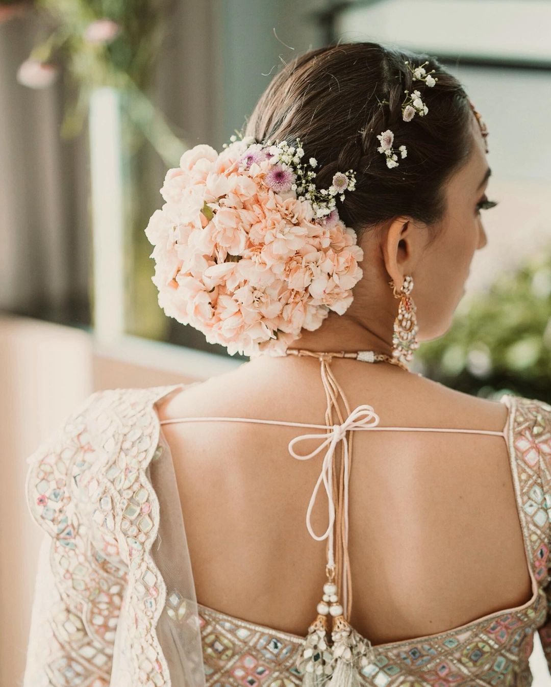 Photo of A twisted bridal bun outlined with white flowers.